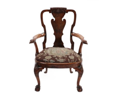 A Carved Walnut Armchair, possibly by Gillows, 19th century, the vasiform solid splat above outswept arms with eagle hand gri