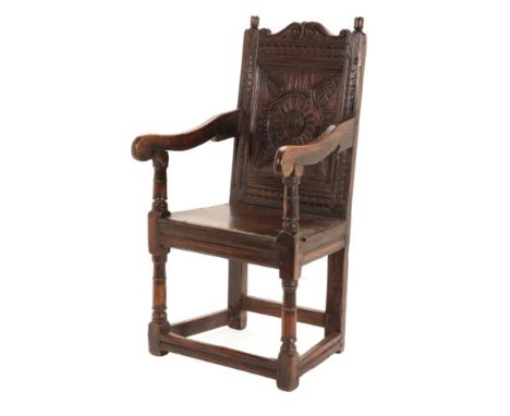 A 17th Century English Joined Oak Armchair, probably North Country, with turned finials above a moulded and carved back panel