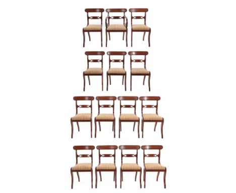 A Set of Fourteen Mahogany Dining Chairs, circa 1820/30, including one carver, recovered in cream and pink striped fabric wit