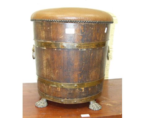 An oak and brass coopered log bin/stool, with metal liner, padded seat and lion mask ring handles, by R A Lister & Co. Ltd, D