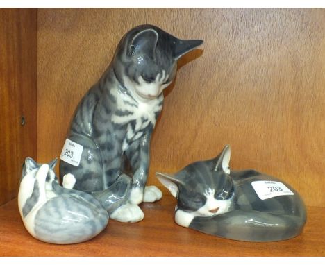 A collection of three Royal Copenhagen cat figures, including 'Grey Seated Cat' No.340, 19cm, 'Tabby Cat Curled Up', No.422 a