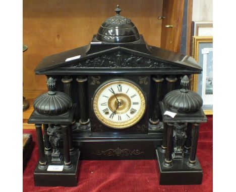 A late-19th century black slate striking mantel clock garniture, the case with domed portico and three sets of reeded pillars