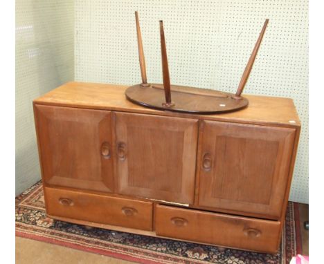 An Ercol medium elm sideboard, the rectangular top above three cupboard doors and two drawers, 129cm long and a small three-l