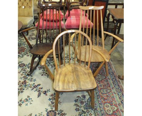 An Ercol light wood spindle-back armchair, one other and a dark wood rocking chair, (3).