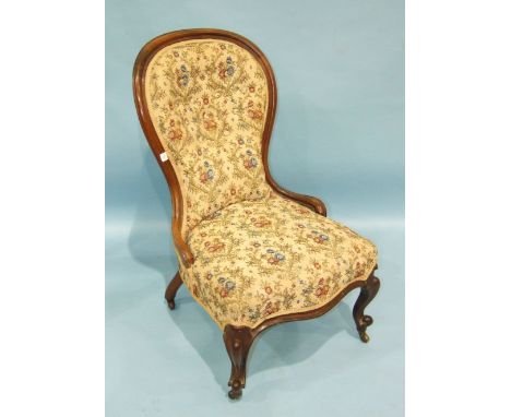 A Victorian rosewood spoon-back nursing chair with serpentine seat and button back, on carved front legs.