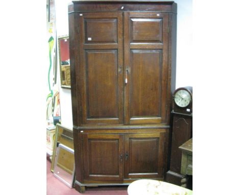 A George III Large Freestanding Oak Corner Cupboard, plain cornice over four folded panel twin doors, above two cupboard door