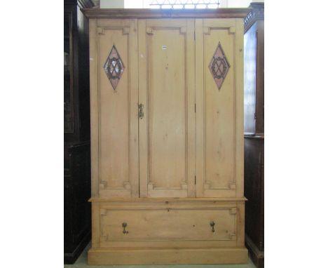 An Edwardian stripped pine wardrobe with Jacobean style mouldings enclosed by a three quarter length central panelled door, f