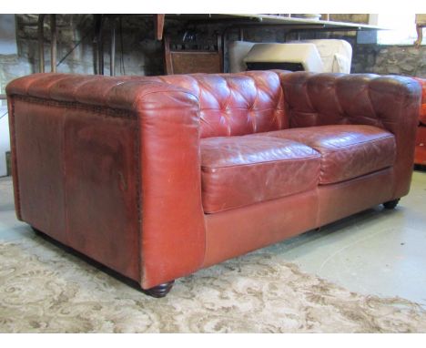 A brown leather upholstered two seat club sofa with button back and fixed seat cushions, 172 cm wide x 96 cm deep x 66 cm hig