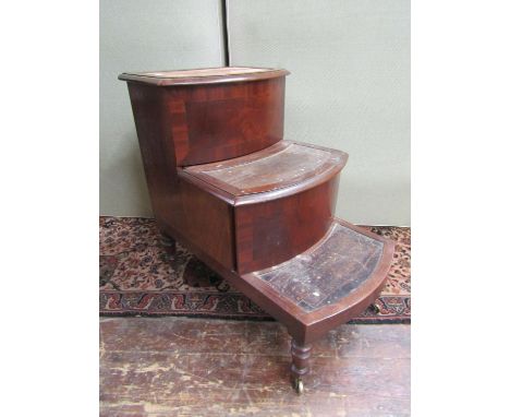 A late Regency period mahogany flight of bed steps, the central treads enclosing a commode, raised on turned supports 