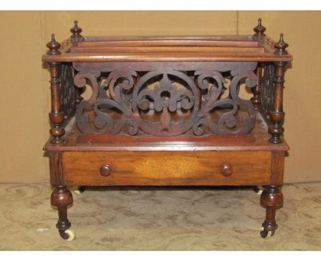 A Victorian walnut three divisional Canterbury with pierced fretwork panels over a frieze drawer with inlaid detail raised on