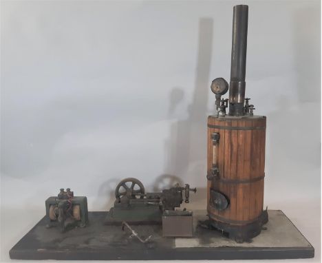 A vintage vertical live steam boiler and stationary single flywheel horizontal engine on platform base; boiler is lagged in p