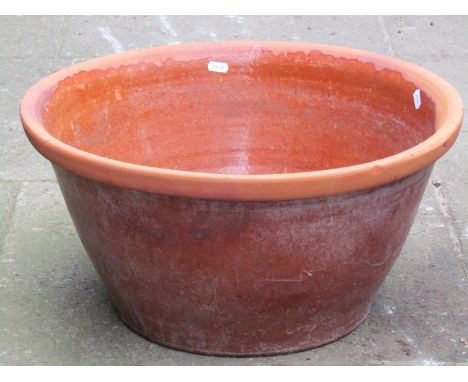 A glazed terracotta pan/crock of circular tapered form (later adapted as a planter with drilled base), 51 cm diameter x 26 cm