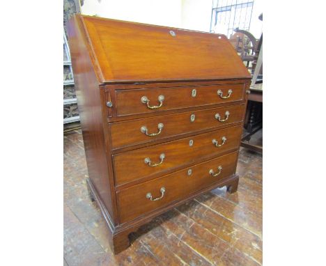 A Georgian countrymade fruit wood and pine bureau of four long graduated drawers, the fall flap enclosing a fitted interior o