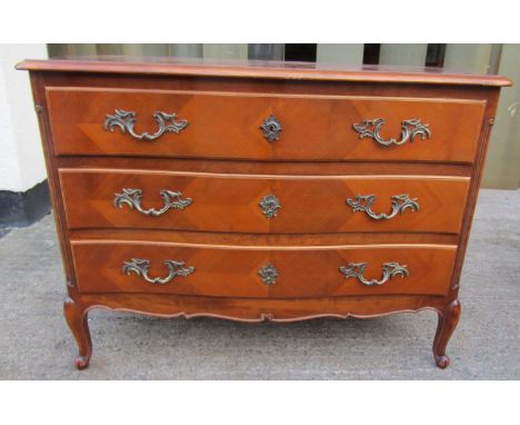 A continental serpentine commode fitted with three drawers on shaped supports with cast brass fittings, 109cm wide 