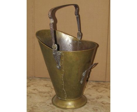 An arts and crafts planished brass helmet shaped coal scuttle with further planished loose loop iron work handle 