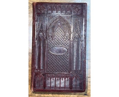 A William IV bible, the dark maroon leather bindings blocked in repeating gothic style architectural detail 
