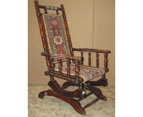 A late 19th century rocking chair with turned frame and carpet seat and back 