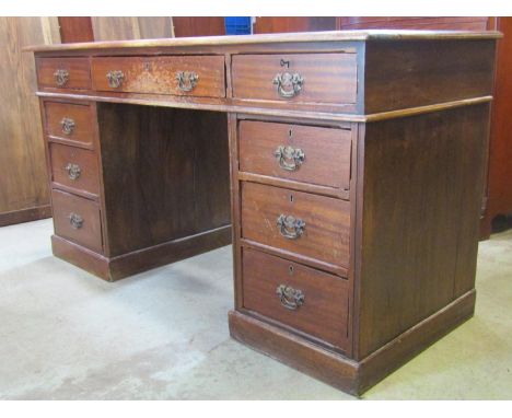 A 19th century mahogany kneehole twin pedestal writing desk with inset green leather panel top over nine frieze drawers, flan