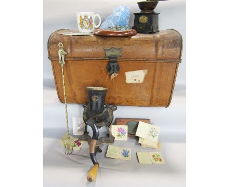 A vintage tin car trunk containing a coffee grinder, a table top meat mincer, a vintage mahogany solitaire board with marbles