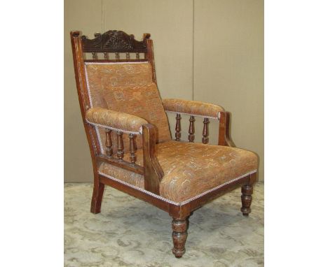 An Edwardian drawing room of parlour armchair with later upholstered seat back and arm pads within a moulded and carved frame