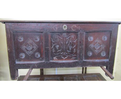 an 18th century oak coffer, the front elevation enclosed by three panels the central panel with abstract floral detail ,flank