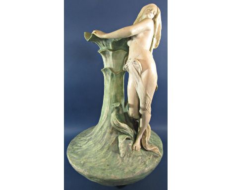 A Goldscheider style Royal Dux lily vase with a woman embracing the petals, indistinctly signed, 60cm high approx.