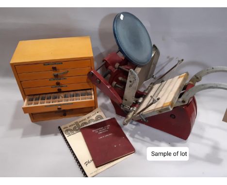 A vintage Adana table top letter press together with a quantity of letter type and accessories, a number housed within three 