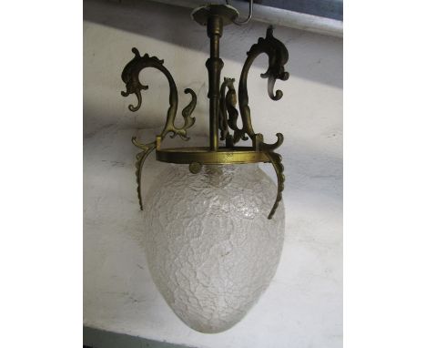 A early 20th century hanging ceiling light with frosted egg shaped glass shade, supported by a gilt brass stem with scrolling