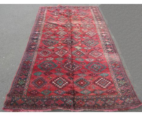 A Bokhara style carpet with an all over geometric hexagonal pattern on a red ground, 290cm x 152cm 