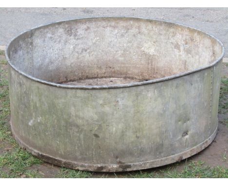 A large circular galvanised steel planter with pop riveted seams and drill base 956 cm diameter x 36 cm high (af) 