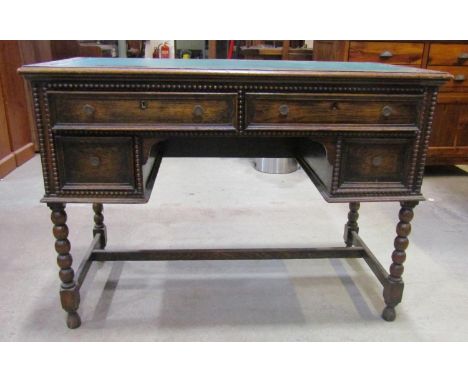 1920s Jacobean style kneehole desk with faux leather inset top over an arrangement of four frieze drawers, flanked by applied