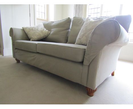 A Multi York Tate model two seat sofa in soft mushroom coloured linen fabric, raised on fluted supports, 2m wide with two cus