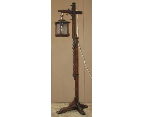 An Old English style oak adjustable standard lamp with square lantern enclosing frosted glass panels 