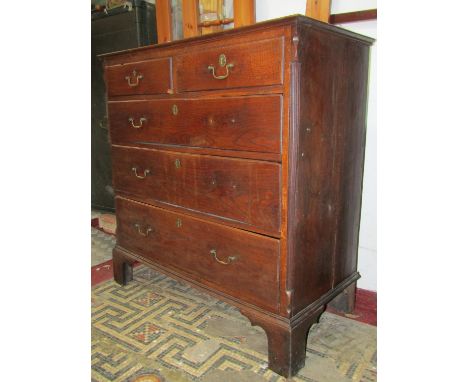 A Georgian oak countrymade bedroom chest of three long and two short graduated drawers flanked by reeded canted corners, set 