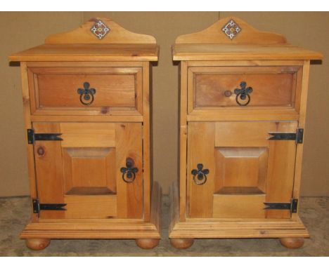 A pair of stripped pine bedside cupboards, each enclosed by a fielded panelled door and frieze drawer with light metal fittin
