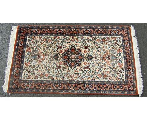 A Persian Tabriz carpet with an all over floral pattern and a central floral medallion.  160cm x 90cm approx 