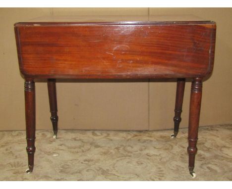 A 19th century mahogany Pembroke table with frieze drawer raised on ring turned and tapered supports with brass caps and cera