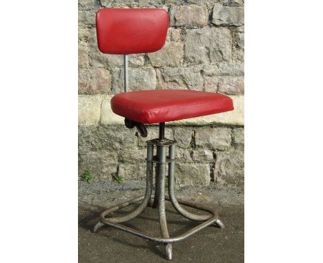 A vintage industrial swivel height adjustable office/typists chair with red vinyl upholstered seat and back raised on swept t