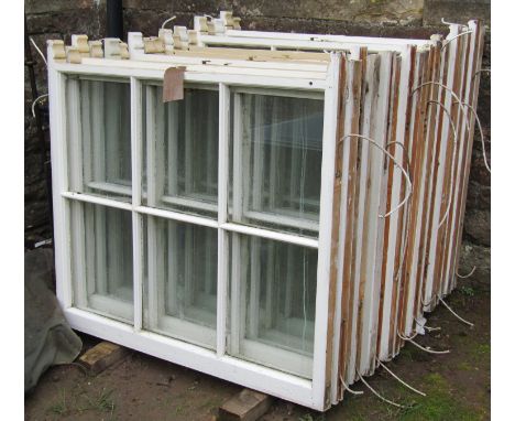 Eighteen reclaimed painted pine sash windows each enclosing six segmented glass panes with brass fittings, 103 cm wide x 94 c