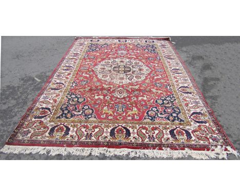 A large Persian Country House Carpet, with a central floral medallion on a field of mystical beasts and trailing flowers on a