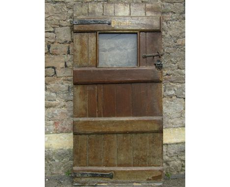 An antique pine ledge and brace internal door with scumbled finish and thumb latch fitting enclosing a rectangular glazed pan