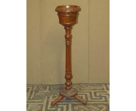 An Edwardian mahogany jardiniere stand with circular tapered brass liner within a slatted frame raised on shaped and swept su
