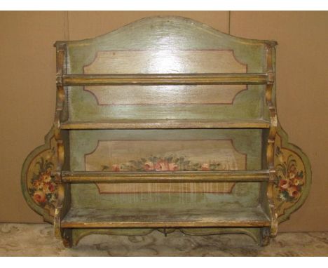 A vintage Italian hand painted wall mounted plate rack with shaped outline and floral detail on a predominantly green ground,
