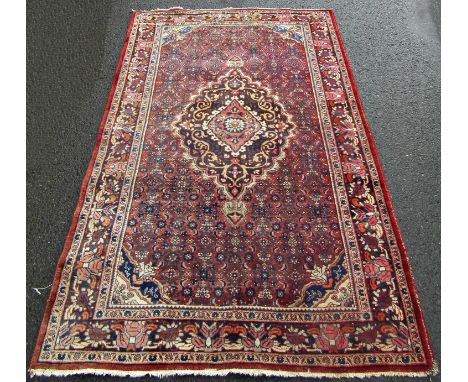 An old slightly worn Hamadan carpet with a floral medallion on a field of stylised flowers.  220cm x 130cm approx. 