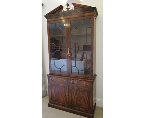 A good quality Georgian style bookcase by Reprodux, the lower section enclosed by a pair of flamed mahogany panelled doors an