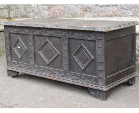 A Victorian oak coffer with hinged lid and panelled frame, the front elevation enclosing lozenge shaped moulded panels and re