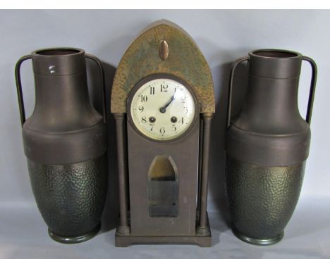 An art nouveau clock garniture in a hammered metallic finish, the clock with eight day striking movement, 46cm high, pendulum