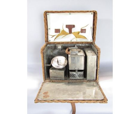 A vintage travelling picnic set with kettle and burner, sandwich box, etc, in its original wicker case basket 