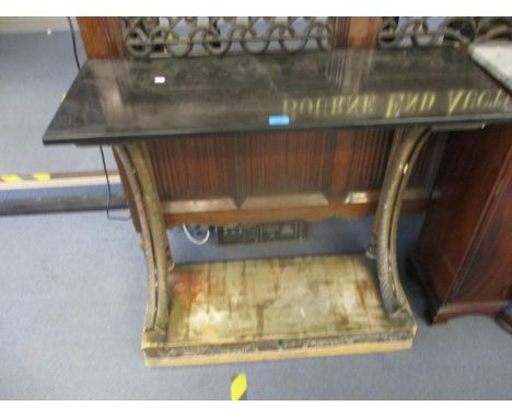 A 20th century painted carved wooden console table with a black marble top, over twin acanthus leaf carved supports on a plin