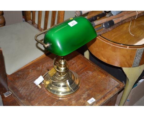 A brass desk lamp with green glass shade